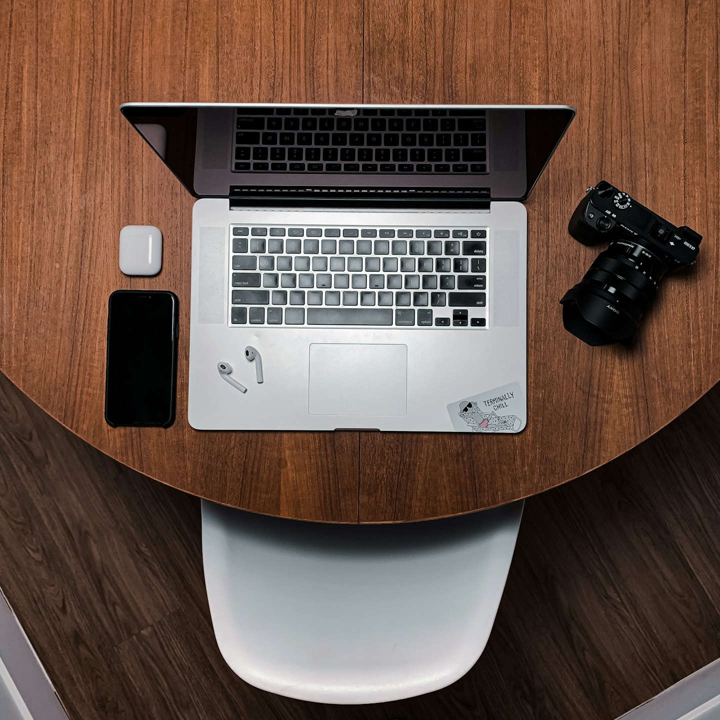 Electronic devices arranged on a round wooden office table.