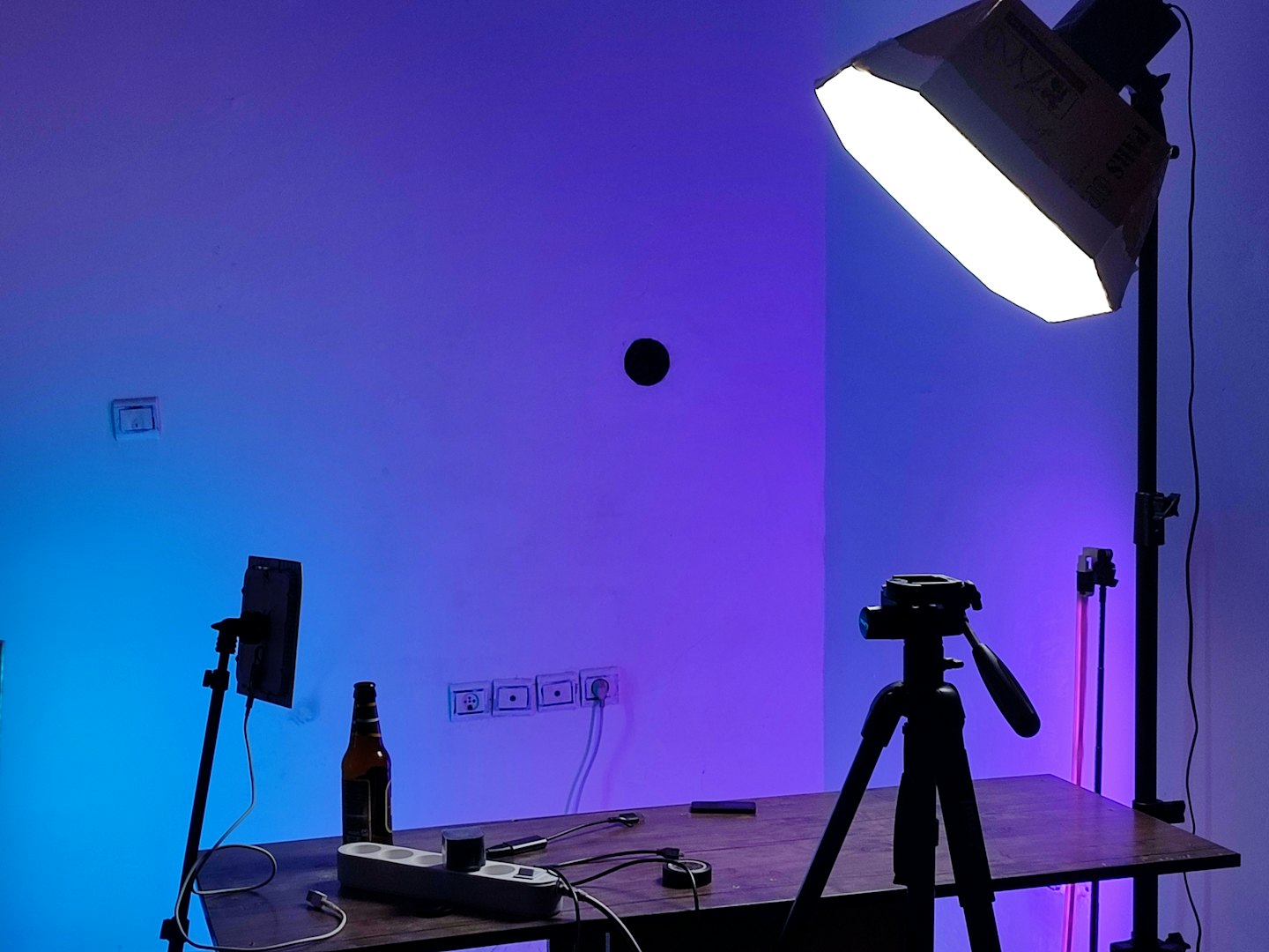 Smartphone, tripod, and softbox on a table for content creation.